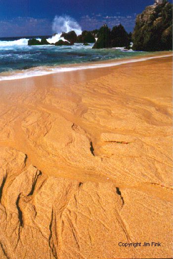 Receding Wave Carves Beach Sand